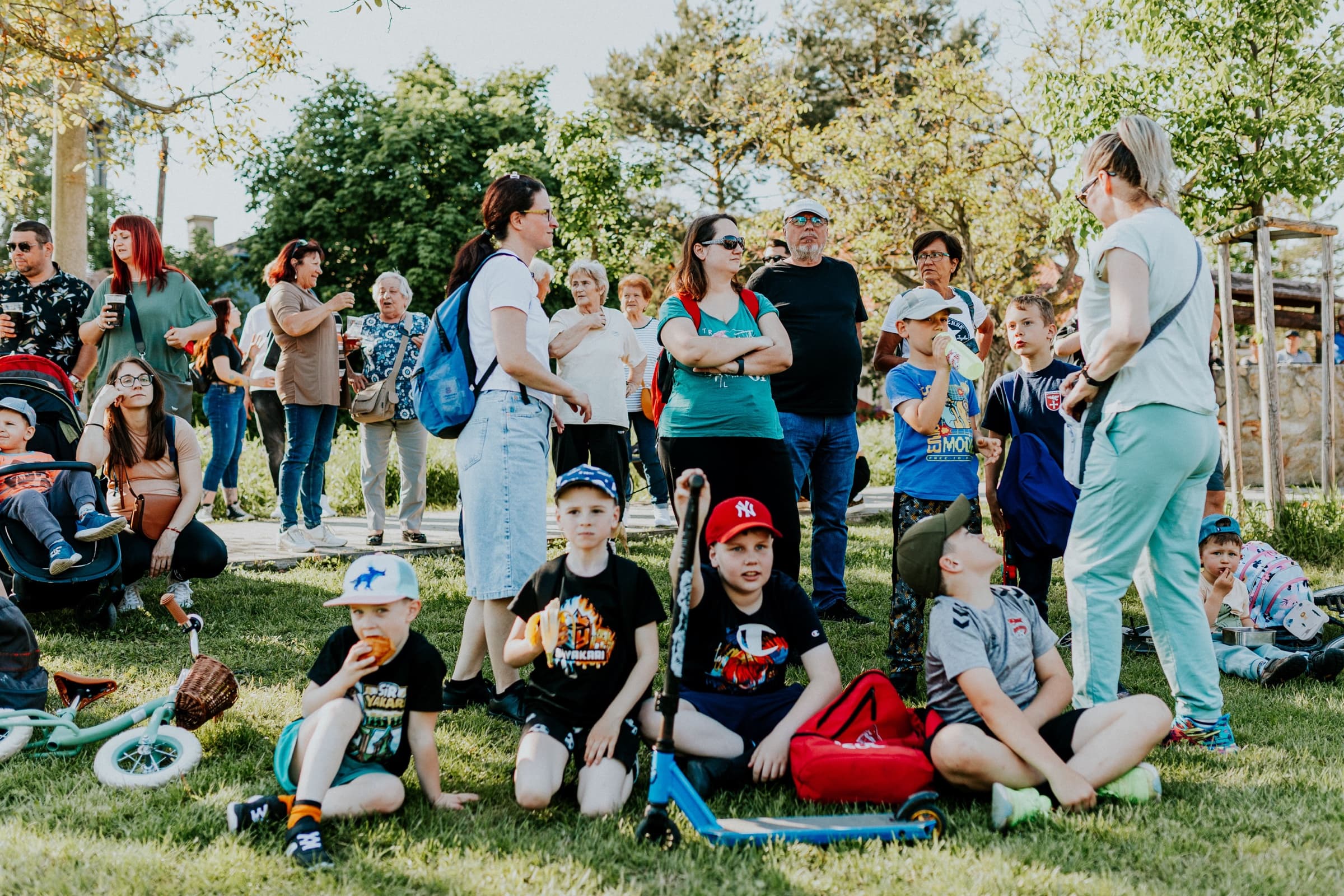 Families, children, and neighbors gathering together in a sunny park