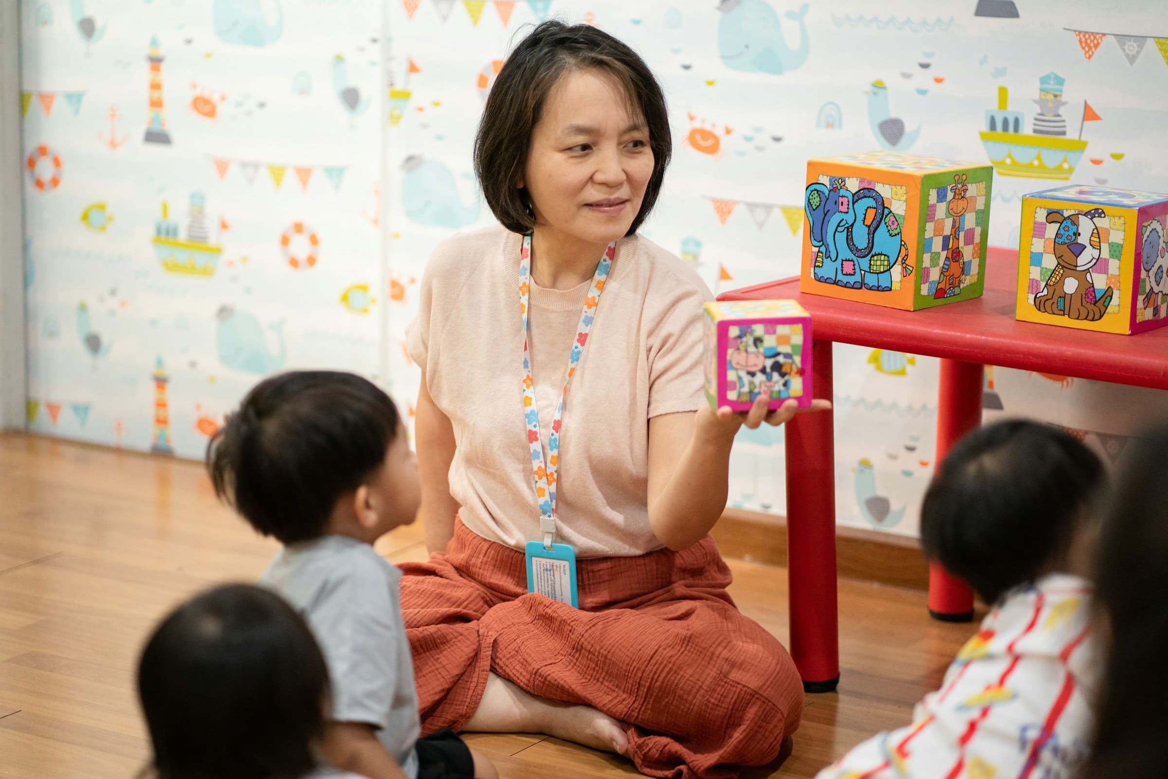 An early childhood educator sharing colorful blocks with a small group of children