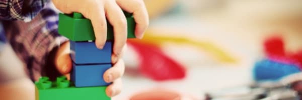 A young child stacking colorful blocks